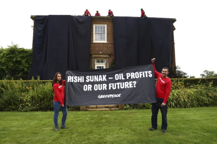 Greenpeace demonstrators drape UK prime minister's house in black to protest oil expansion