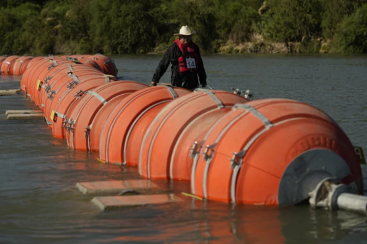 A judge orders Texas to move a floating barrier used to deter migrants to the bank of the Rio Grande